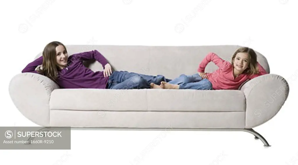 Portrait of two sisters lying on a couch