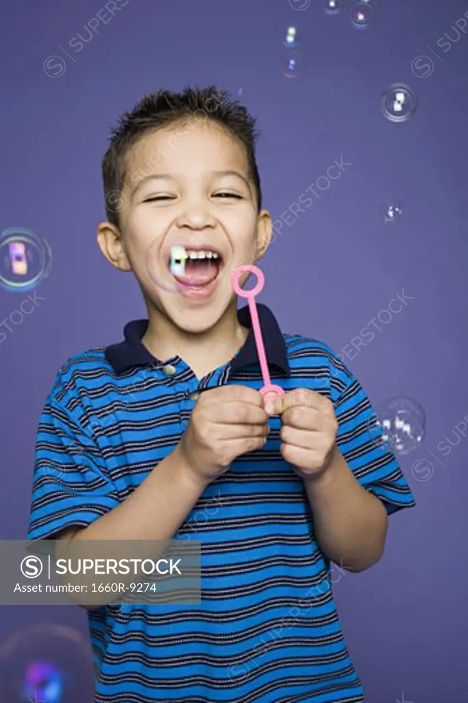 Close-up of a boy blowing bubbles with a bubble wand