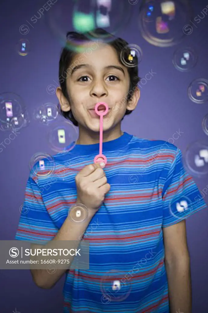 Portrait of a boy blowing bubbles with a bubble wand