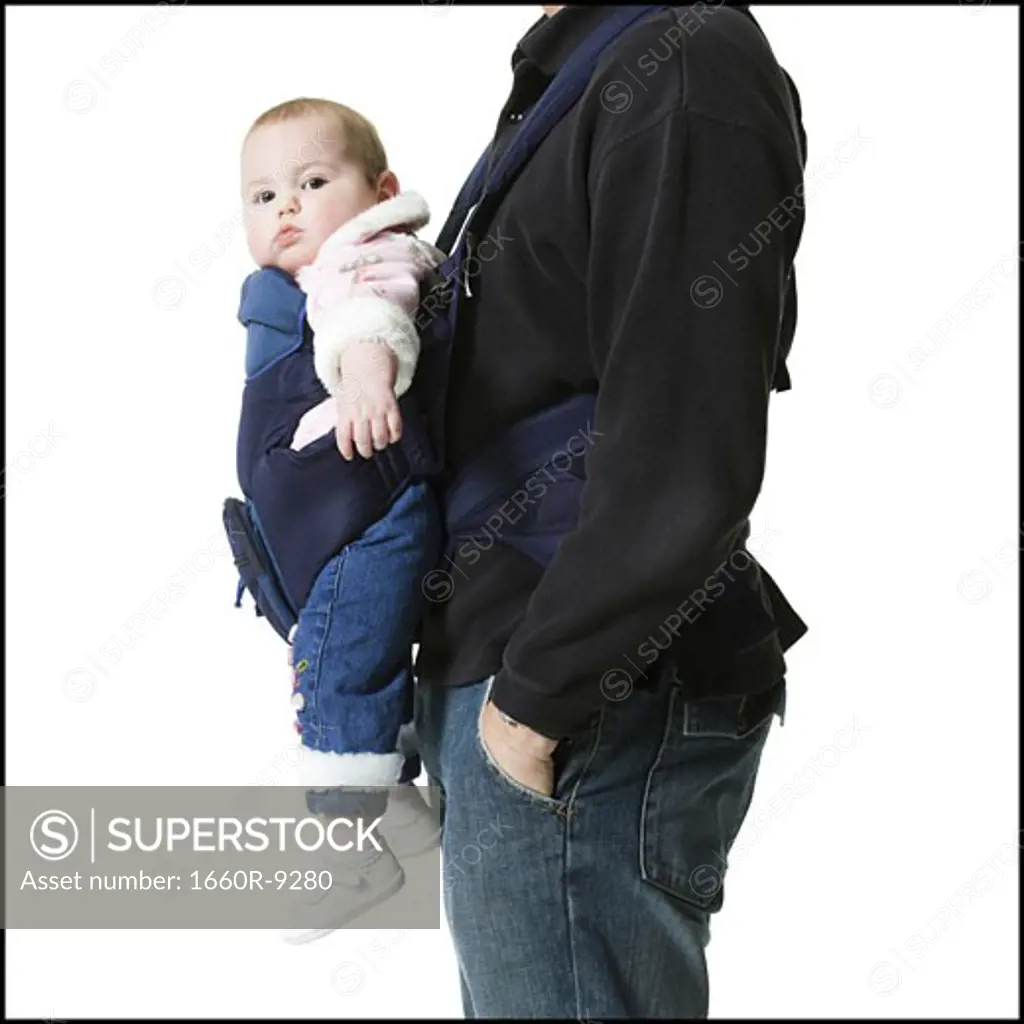 Mid section view of a mature man carrying his daughter