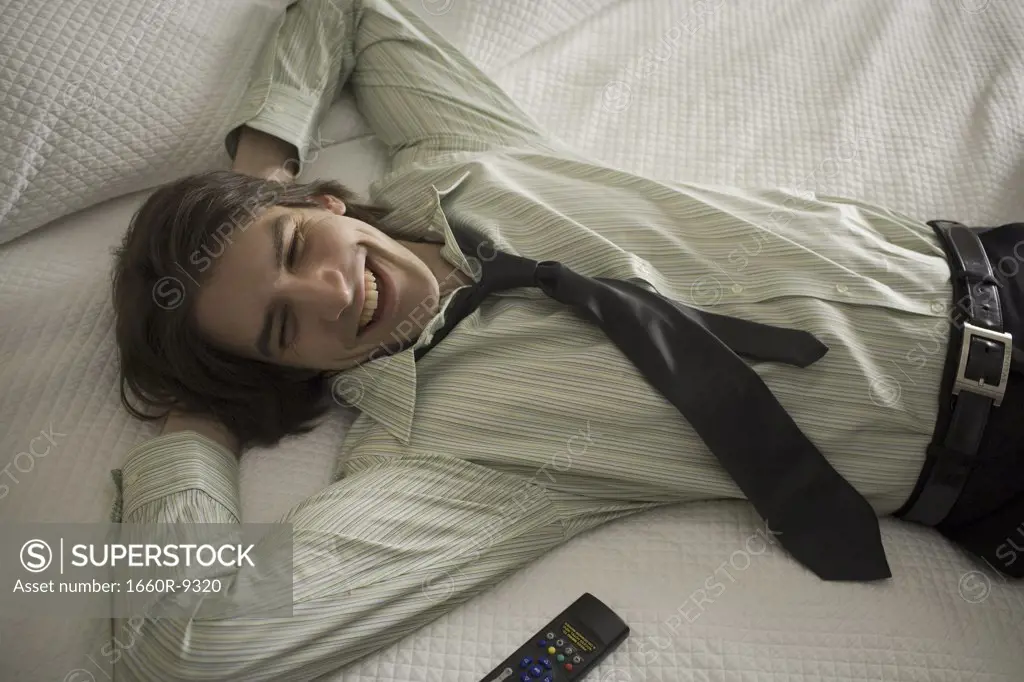 High angle view of a businessman lying on the bed