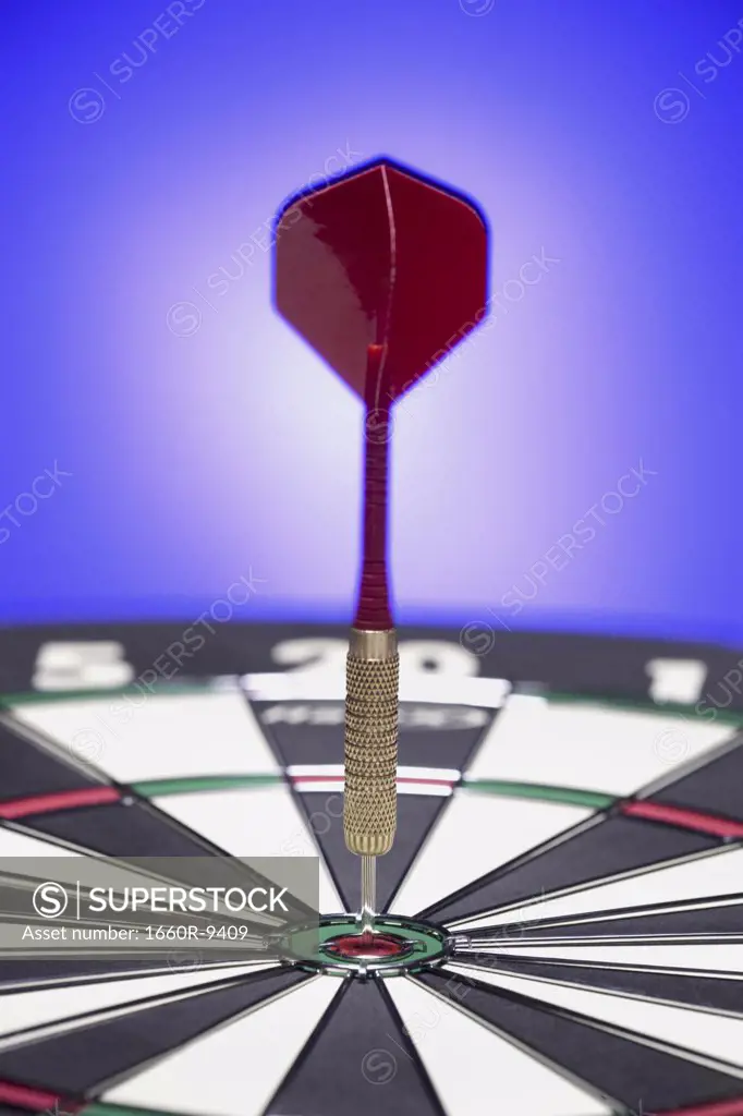 Close-up of a dart on the bull's eye of a dartboard