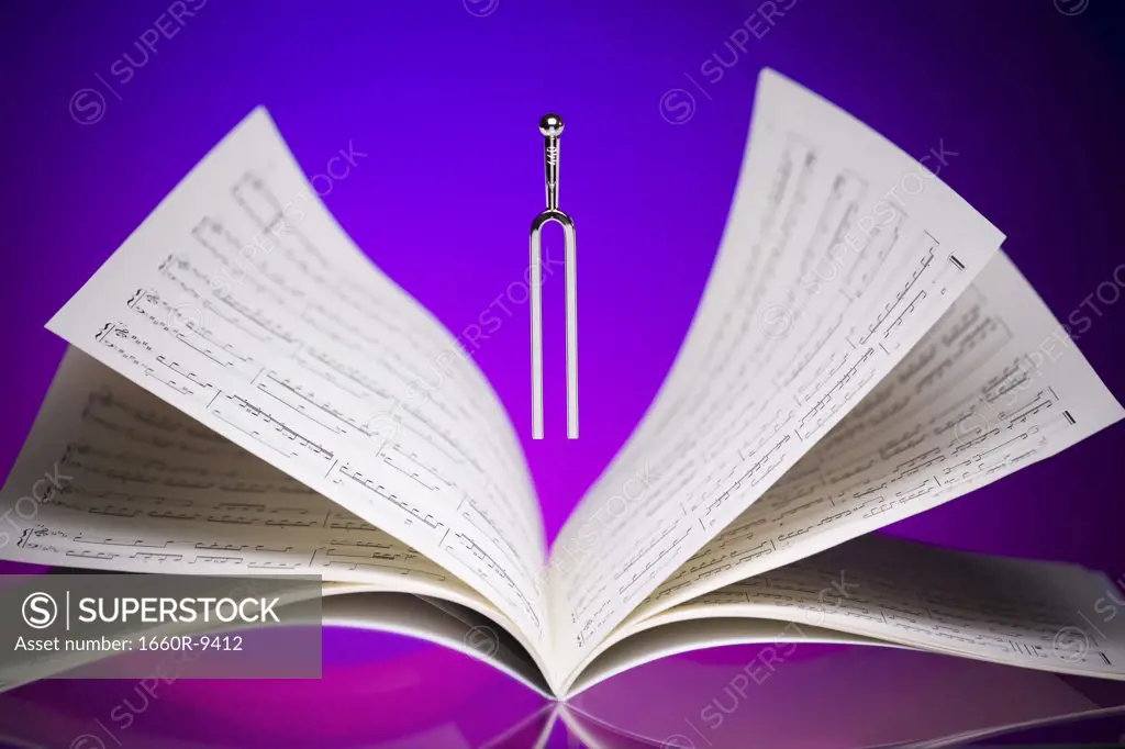 Close-up of a tuning fork and music sheets
