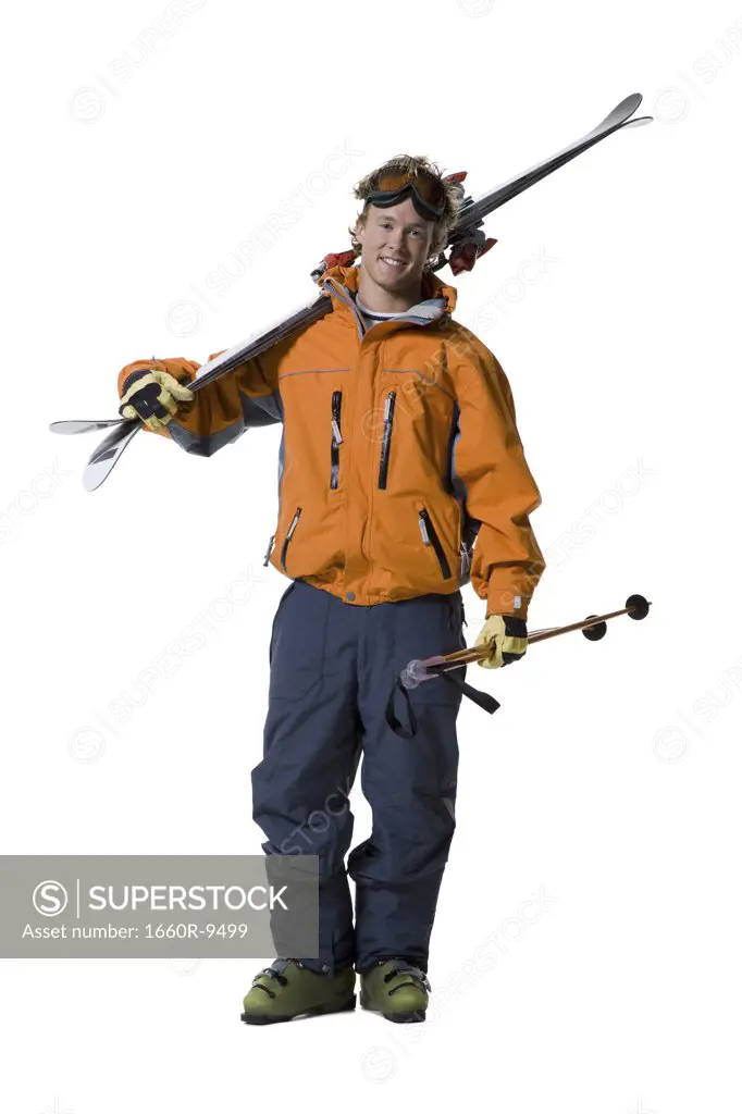 Portrait of a young man holding skis and ski poles
