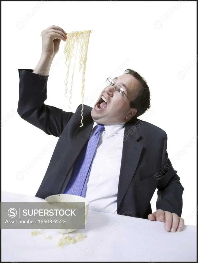 Close-up of a young man eating noodles with chopsticks