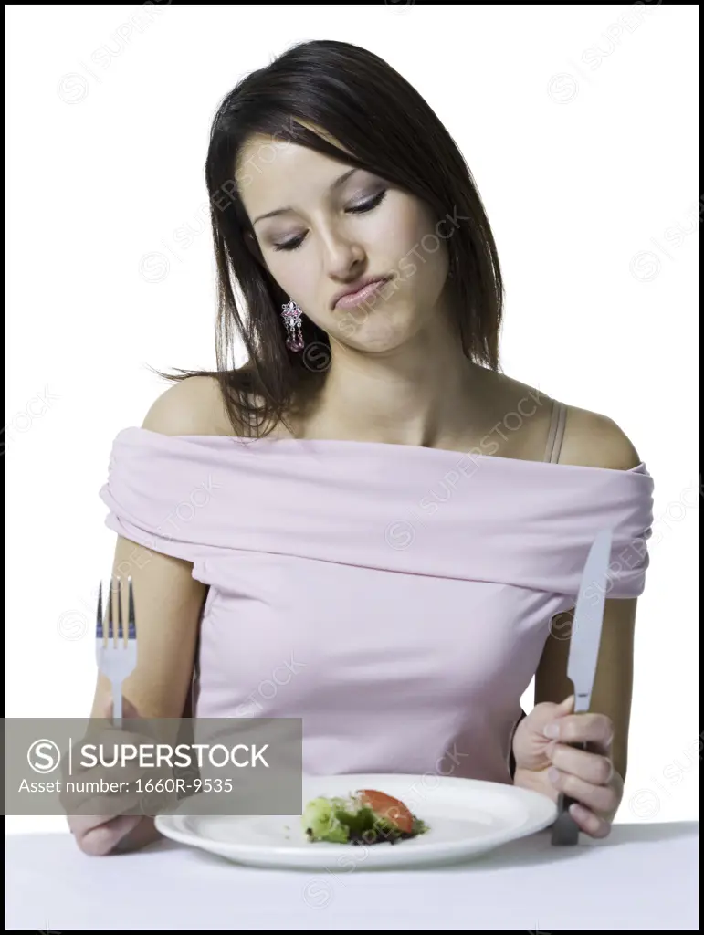 Close-up of a young woman sitting with only a very small portion of food