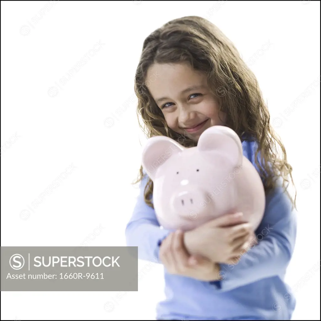 Portrait of a girl holding a piggy bank