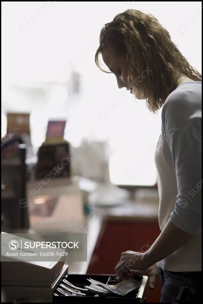 Profile of a young woman standing at a checkout counter