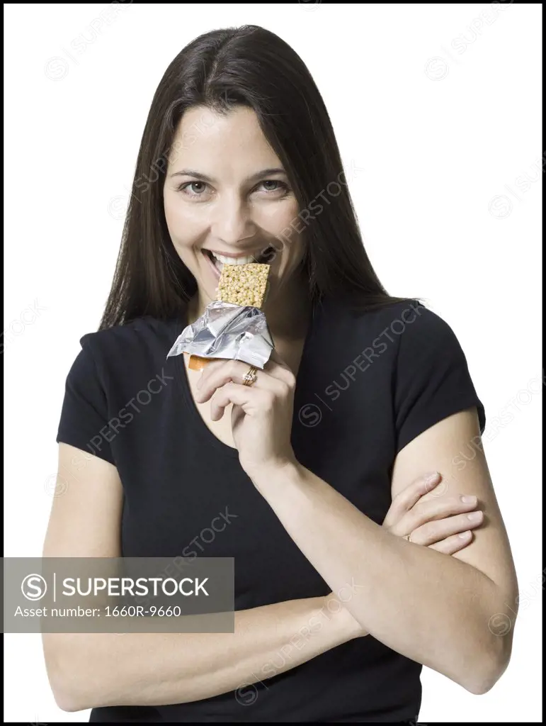 Portrait of a woman eating a granola bar