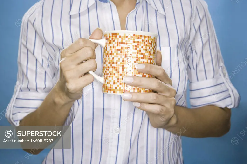 Mid section view of a woman holding a mug
