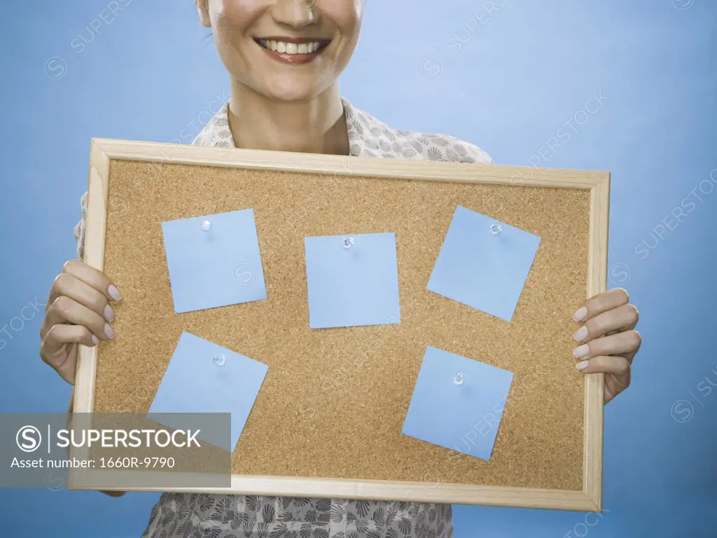 Close-up of a young woman holding a bulletin board