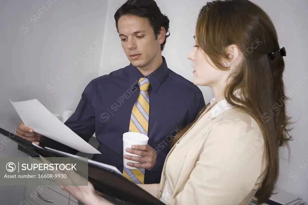 Businessman and a businesswoman looking at a file