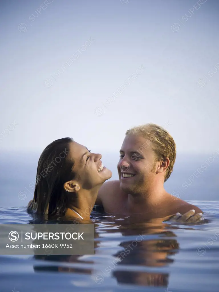 Young couple smiling together in a swimming pool