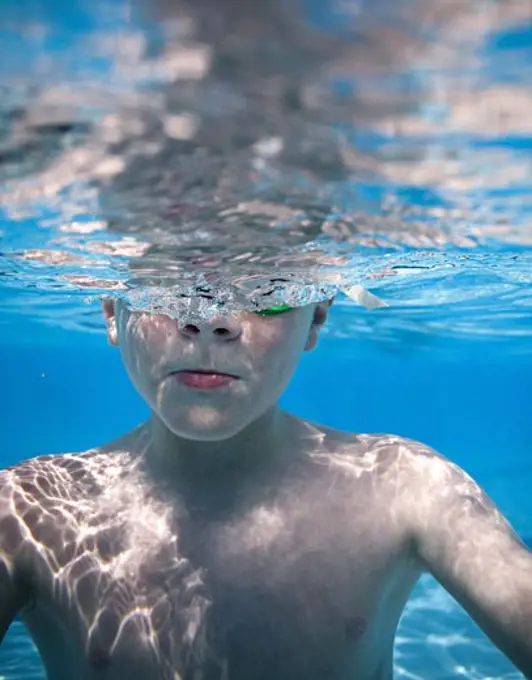 Boy swimming underwater in pool