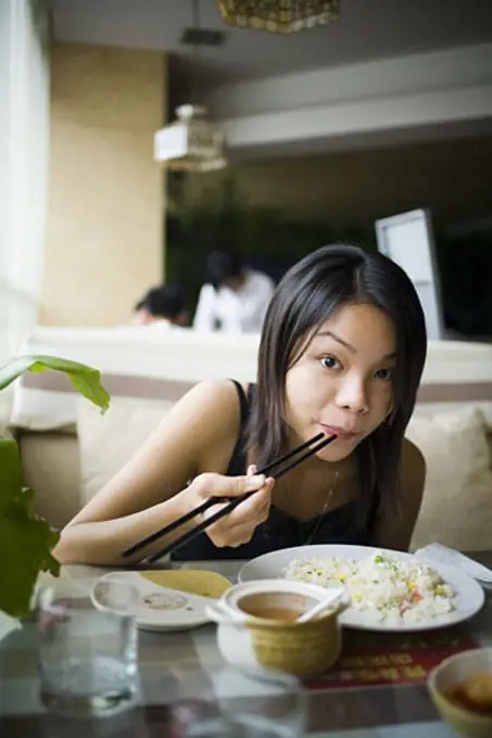 Woman eating at a Chinese food restaurant