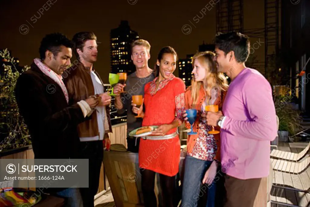 Group of women and men standing and holding drinks