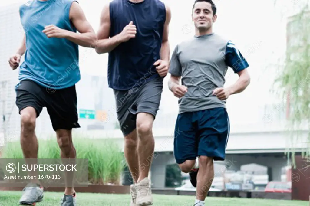 Close-up of three young men jogging
