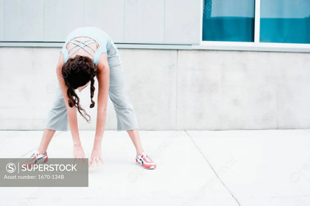 Young woman exercising on a sidewalk