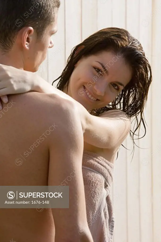 Portrait of a young woman embracing a young man
