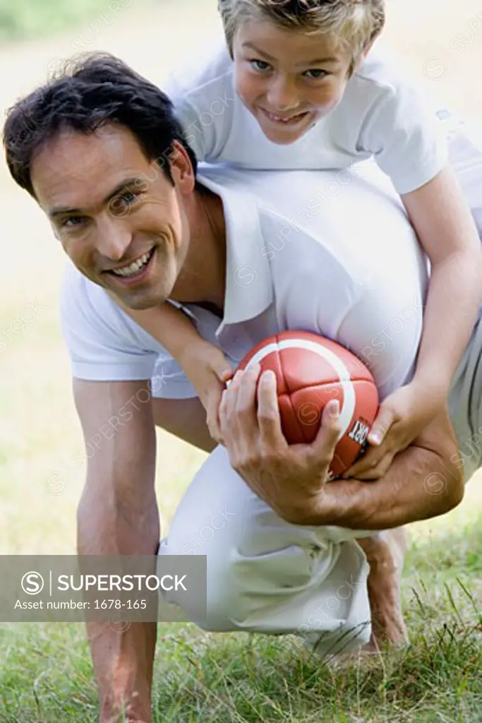 Mid adult man and his son playing with a football