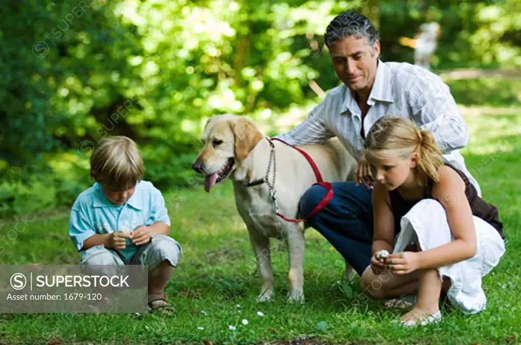 Mid adult man with his two children and a dog in a park