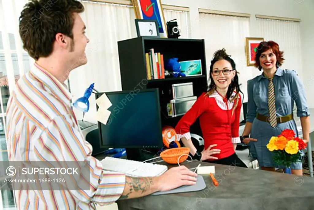 Businessman with two businesswomen standing in an office