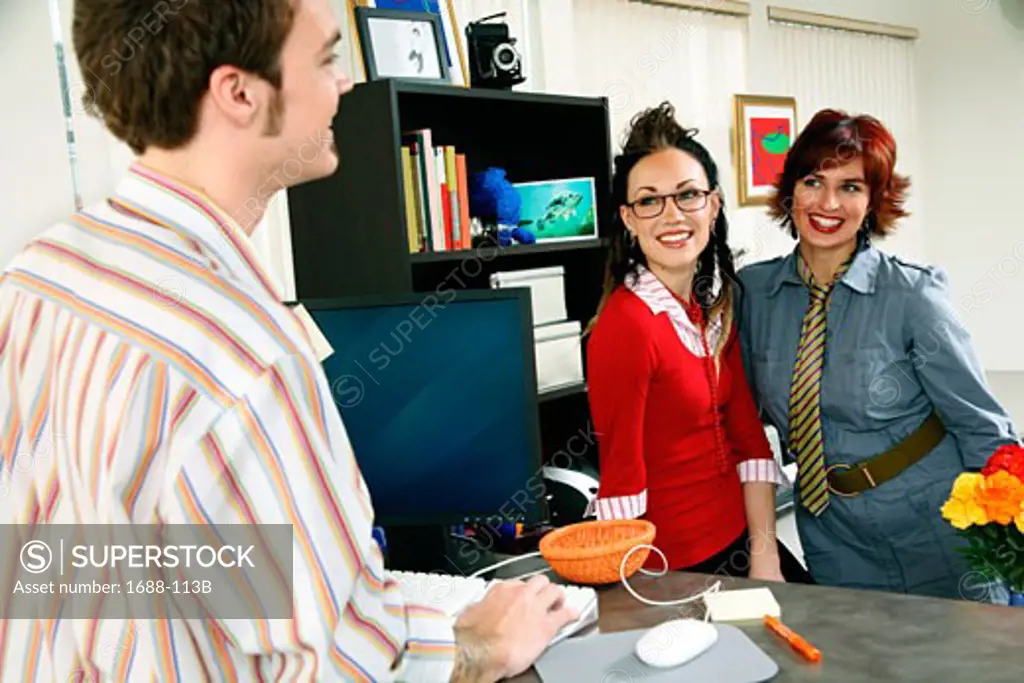 Businessman with two businesswomen standing in an office