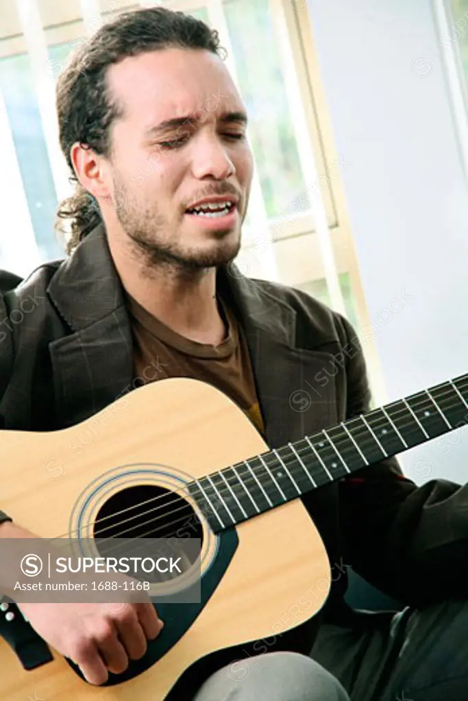 Young man playing a guitar and singing
