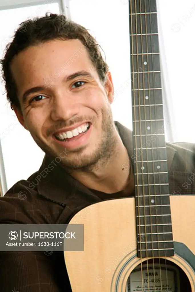 Portrait of a young man holding a guitar