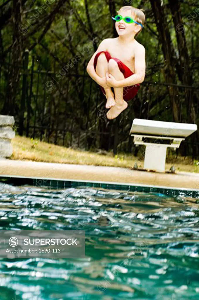 Low angle view of a boy jumping off a diving board