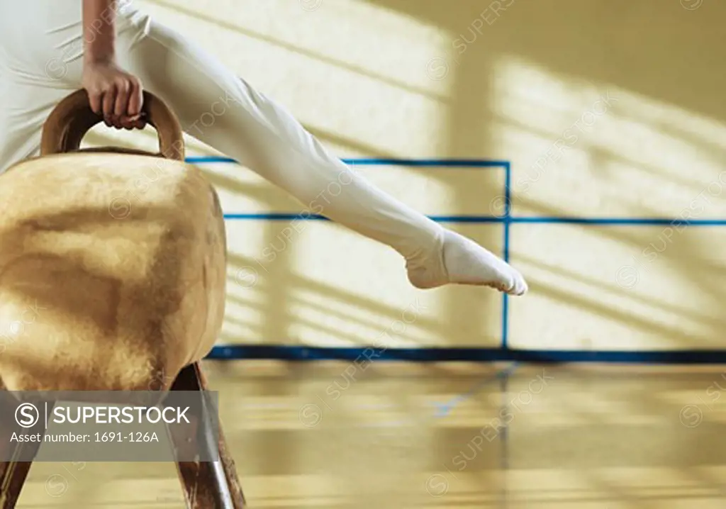 Male gymnast performing on a pommel horse