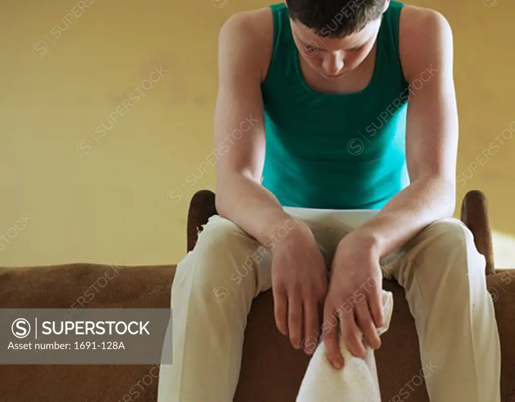 Male gymnast sitting on a pommel horse