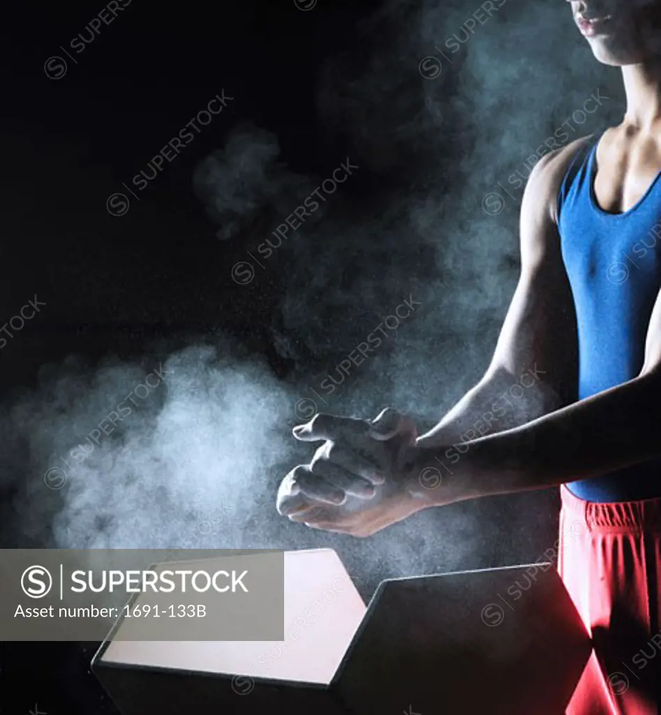 Male gymnast applying powder to his hands