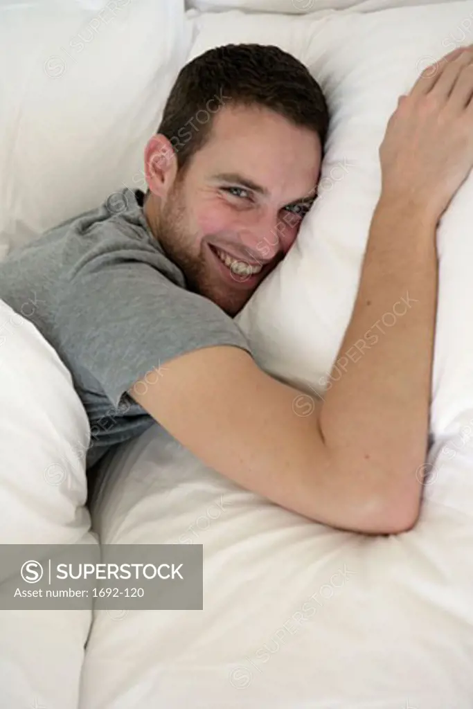 Portrait of a young man lying in bed