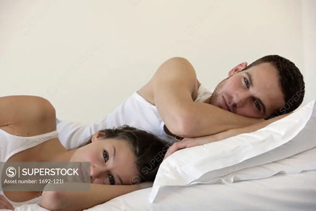 Portrait of a young couple lying in bed