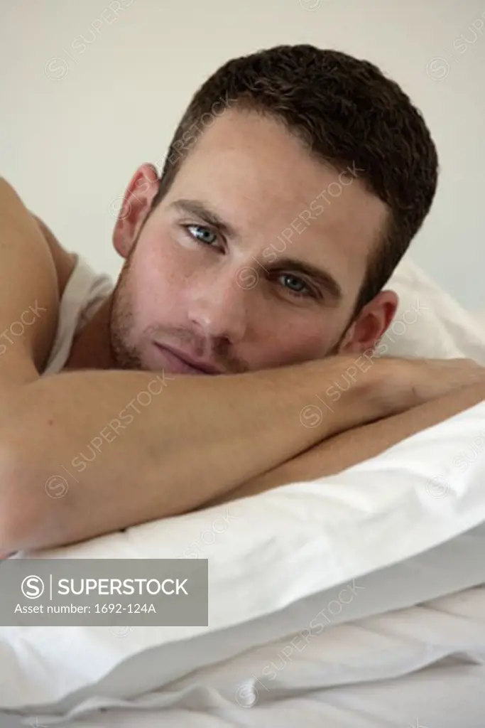 Portrait of a young man lying in bed