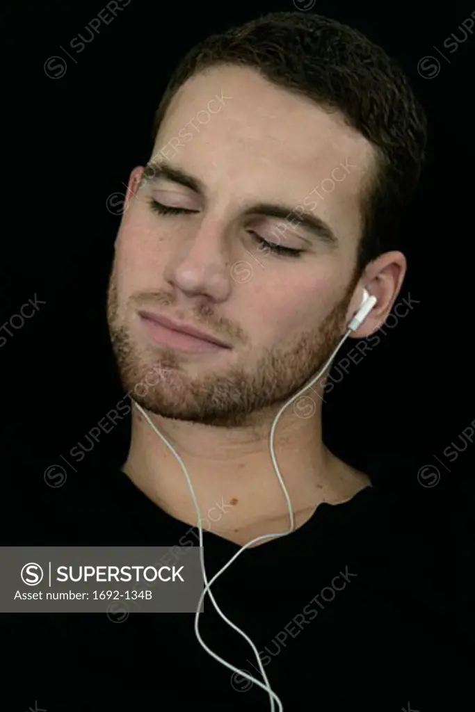 Close-up of a young man listening to headphones