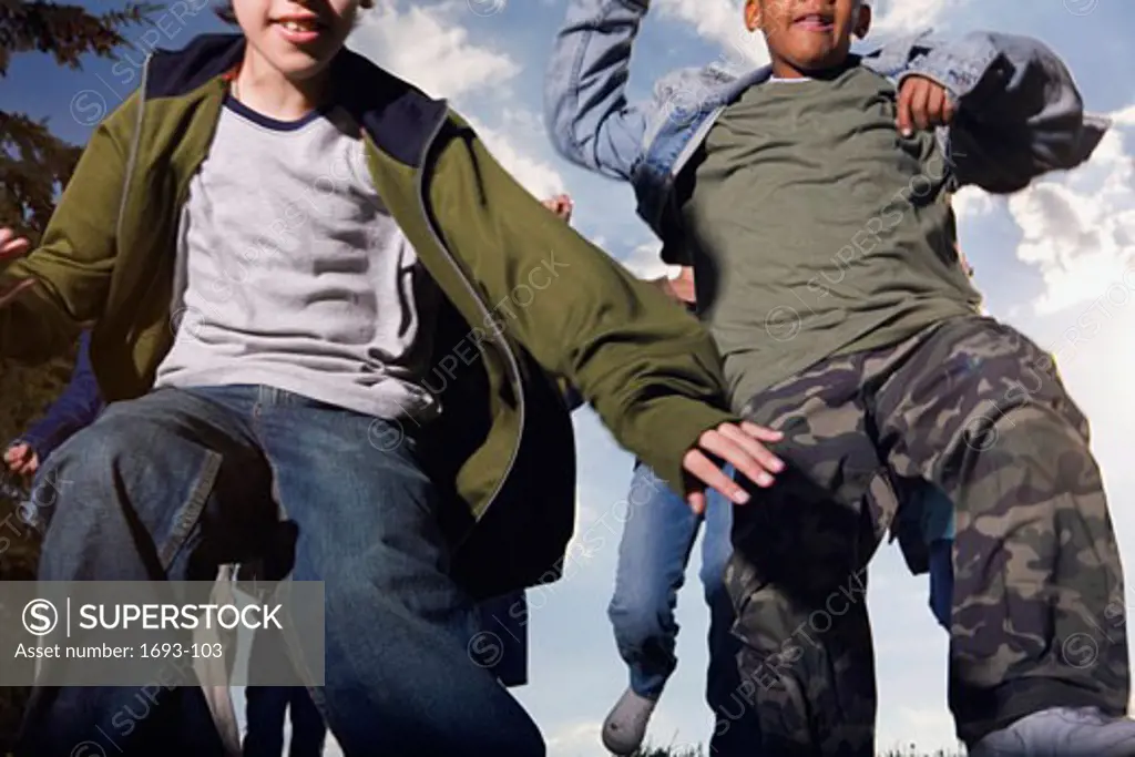 Low angle view of two boys jumping