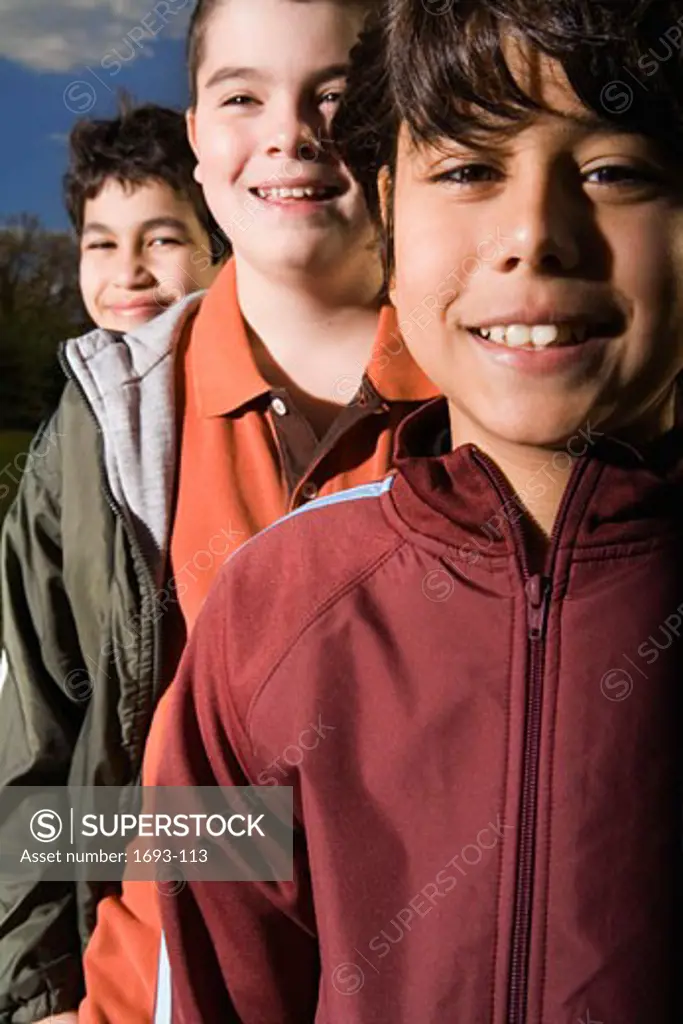 Close-up of three boys in a row