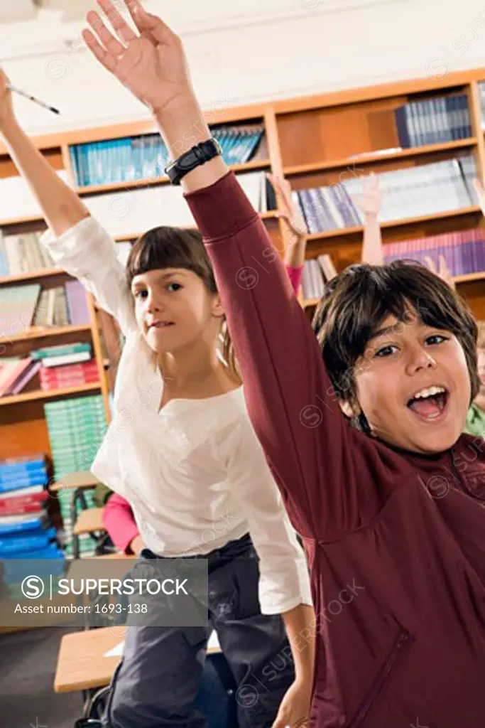 Boy and girl raising their hands