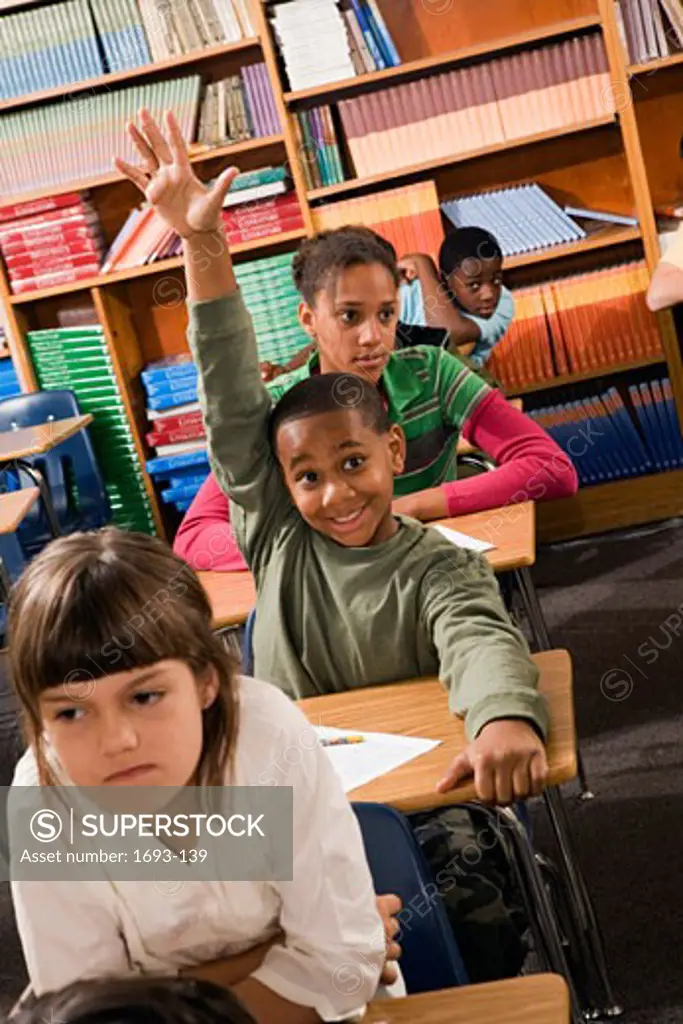 Boy raising his hand in a classroom