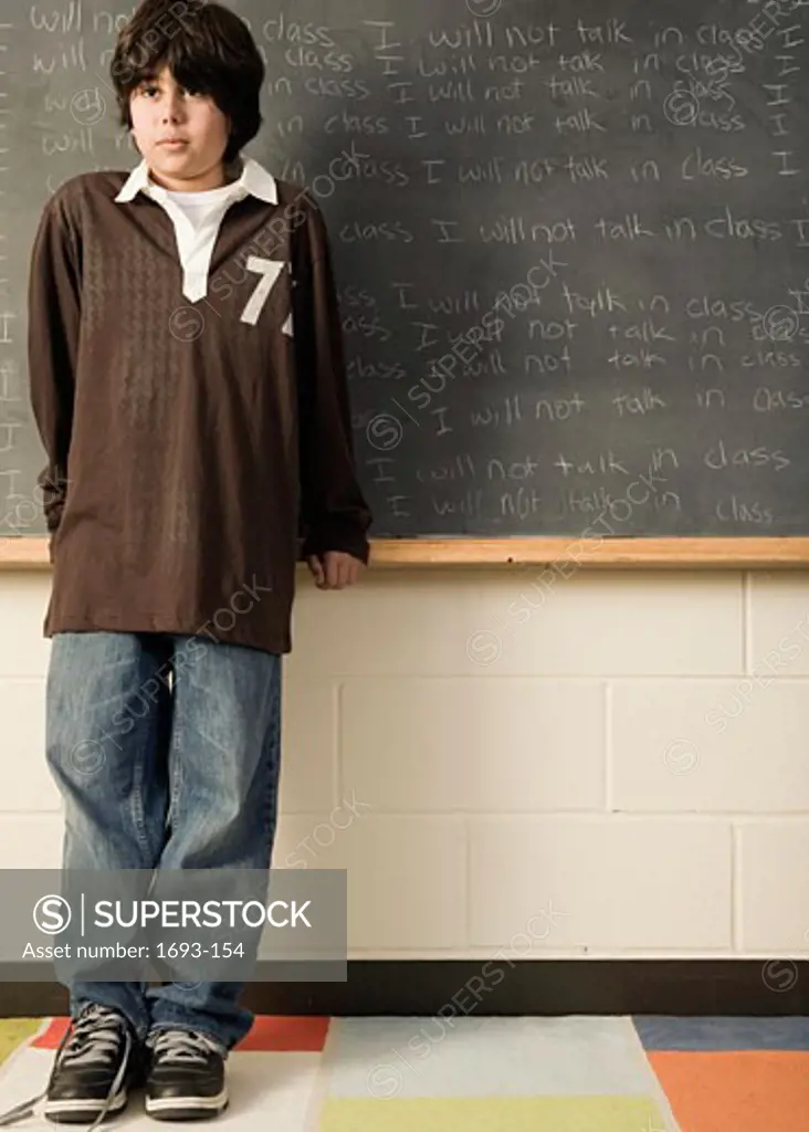 Boy standing in front of a chalkboard