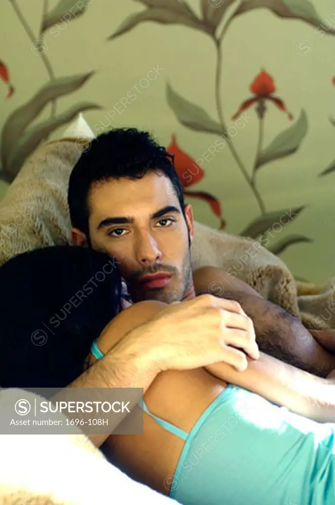 Young man embracing a young woman in bed