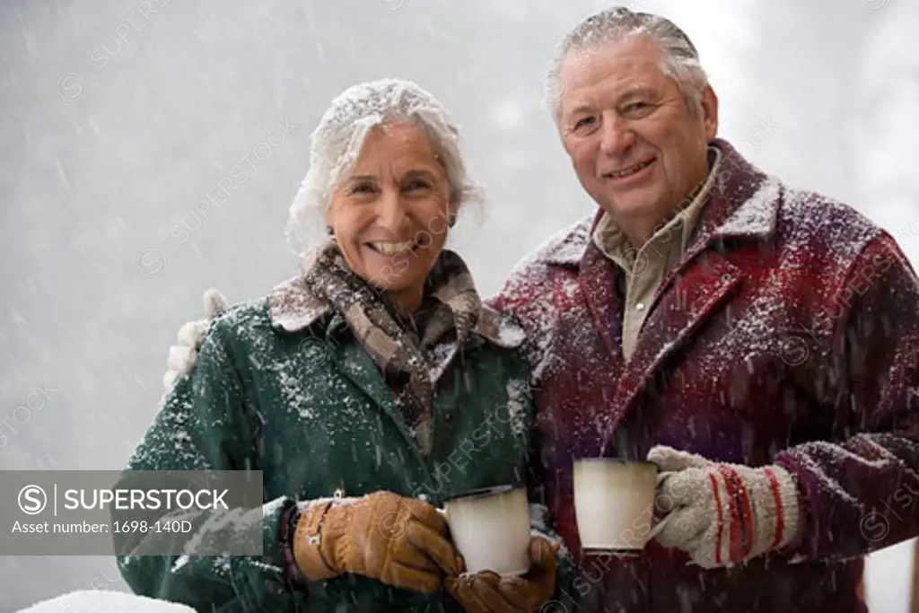 Portrait of a senior couple holding coffee cups