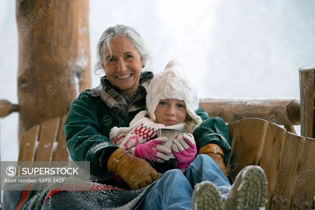 Senior woman sitting with her granddaughter on a bench