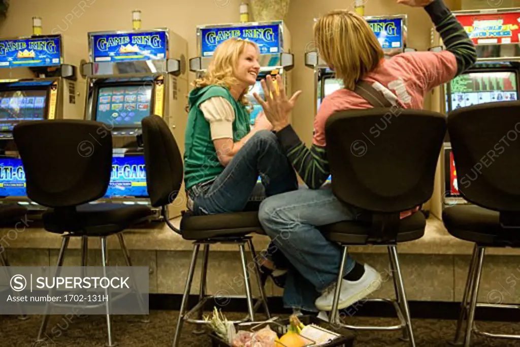 Young couple sitting in front of slot machines in a casino