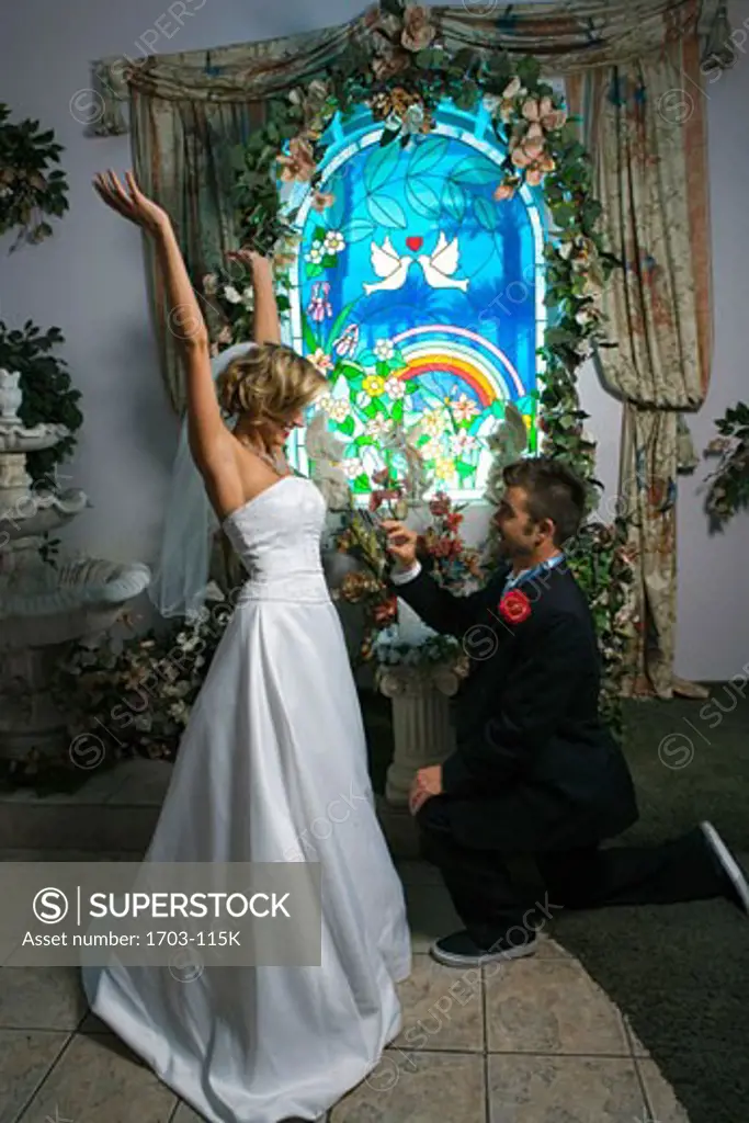 Bride and groom in front of a stained glass window