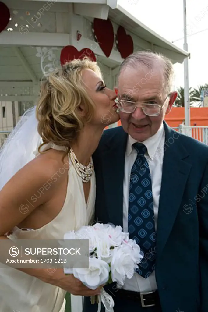Bride kissing a senior man on the cheek