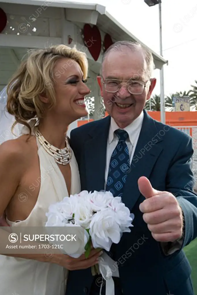 Bride smiling with a senior man giving a thumb's up