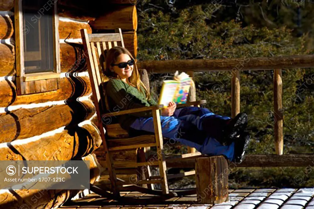 Girl sitting in a rocking chair and reading a book